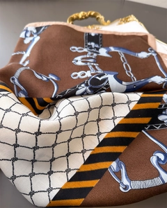 Close-up of equestrian chain print silk scarf with luxury horse harness pattern