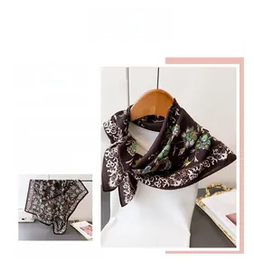 Detail of dark brown scarf with green floral paisley pattern and smooth silk texture