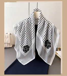 Detailed view of the French style polka dot and camellia pattern on the black silk scarf