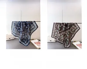 Detail view of navy and coffee floral print silk scarves with vintage pattern textures