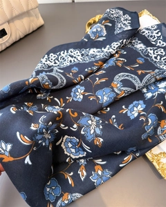 Detailed view of the dark blue floral pattern and twill texture on a cotton linen feel scarf
