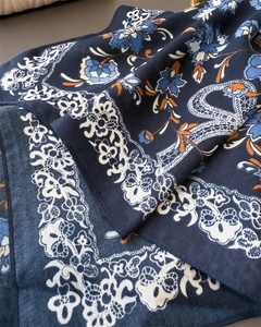 Detailed close-up of dark blue floral scarf with silk texture and intricate patterns