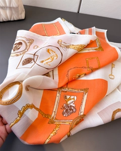 Detailed view of vintage orange silk scarf with retro portraits and chain patterns