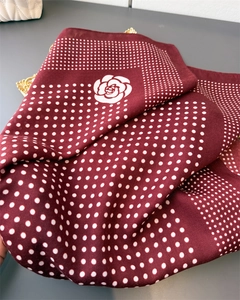 Detailed texture of burgundy silk scarf featuring white camellia and polka dot patterns