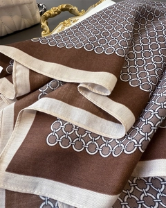 Detail of herringbone weave and geometric chain pattern on soft brown and beige scarf