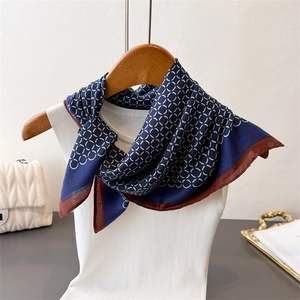 Geometric interlocking ring pattern silk scarf in navy and wine red on a wooden hanger