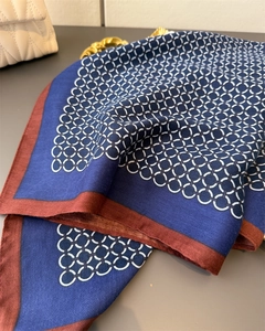 Detail of navy and red silk-like square scarf featuring white chain pattern and smooth texture