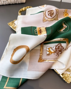 Detail of vintage herringbone silk-like scarf with retro fashion print on golden tray