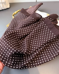 Close-up of lightweight dark brown silk scarf with white polka dot pattern and soft satin sheen