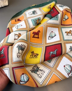 Gros plan d'un foulard en soie sergé avec motif équestre de chevaux et casques