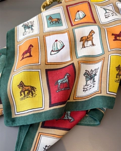 Détail d'un foulard équestre à carreaux avec imprimé de chevaux et texture en soie vintage