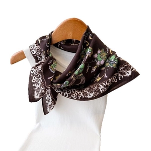 Dark brown floral printed scarf with white lace pattern on a white mannequin