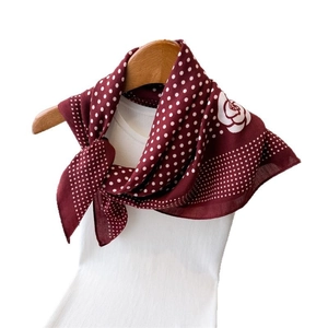 Burgundy polka dot and rose pattern square silk-like scarf draped on a hanger