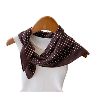 Minimalist dark brown polka dot scarf displayed on a wooden hanger with white top