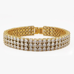 Bracciale tennis dorato a tre file con zirconi bianchi scintillanti su sfondo bianco