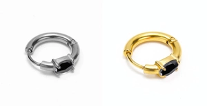 Detail of silver and gold huggie earrings with oval black zircon in four-prong setting