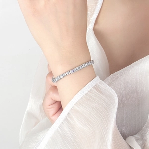 Macro detail of silver tennis bracelet with square-cut 3A cubic zirconia in claw setting
