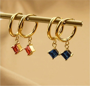 Detailansicht von 18K Goldohrringen mit quadratischen roten und blauen Zirkonia-Anhängern
