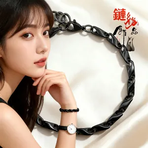Détail d'une chaîne noire, d'un bracelet et d'une montre dorée sur soie blanche