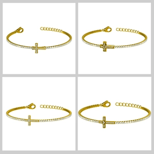 Détail du bracelet croix dorée avec zircons montrant le fermoir mousqueton et la chaîne