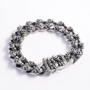 Detailed close-up of heavy stainless steel cuban chain bracelet with skull carvings