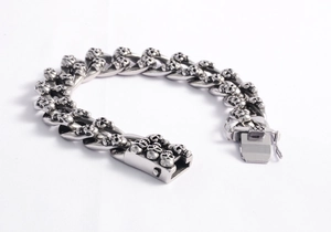 Close-up of vintage stainless steel Cuban chain bracelet with detailed skull links