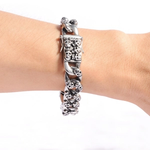 Detailed close-up of vintage stainless steel Cuban link bracelet with skull embossing
