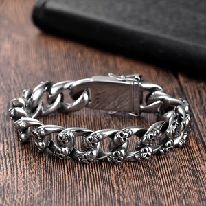 Detailed view of punk style stainless steel Cuban link bracelet with skull engravings