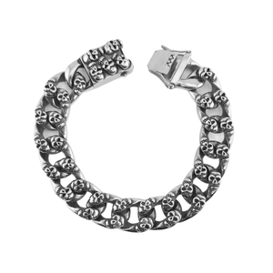 Gothic silver stainless steel Cuban bracelet with detailed triple skull relief links