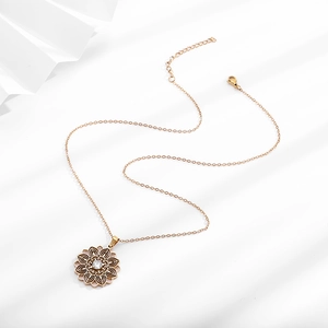 Close-up of golden mandala flower pendant with white zircon and delicate metal chain