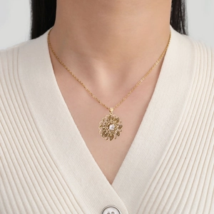 Ethnic style gold flower necklace with zircon pendant worn on a female model