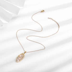 Close-up of golden oval hollow pendant necklace with three inlaid zircons and lobster clasp