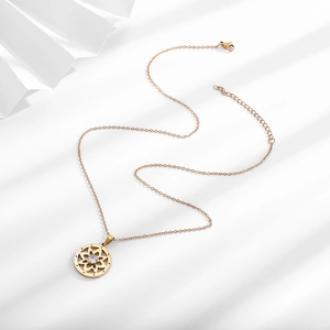 Detailed shot of gold lotus pendant necklace with zircon stone on white background