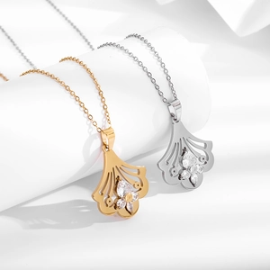 Elegant ginkgo leaf necklace in gold and silver finish with zircon stones on white display
