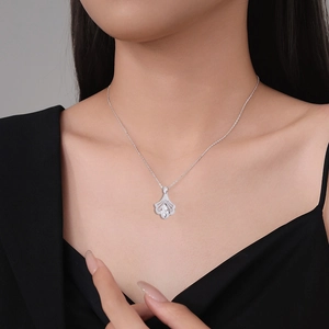 Close-up of fan-shaped ginkgo leaf necklace with sparkling crystals on model's neck