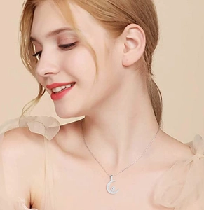 Close-up of elegant crescent moon pendant necklace with crystals on model neck