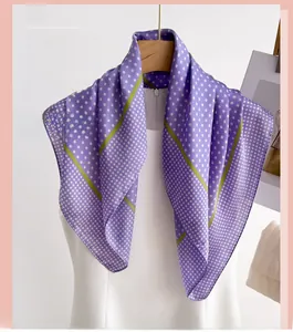 Detailed view of purple polka dot silk scarf with green borders on a model