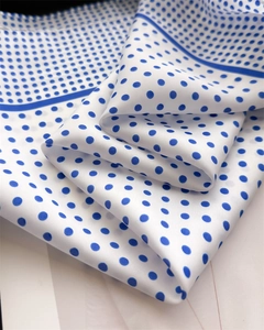 Detailed view of polka dot silk scarf with elegant navy blue borders and smooth folds
