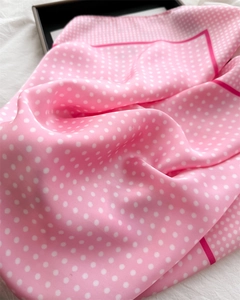 Detailed close-up of pink polka dot silk scarf with elegant drape and satin finish