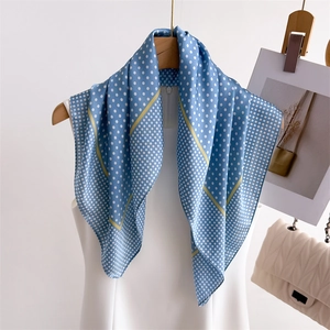 Elegant blue silk scarf with white polka dots and yellow borders on a dress