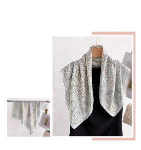 Detail of elegant paisley print scarf in cream and green with silky smooth texture