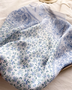 Detail view of the paisley pattern and floral print on soft silk-like square scarf