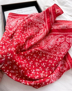 Macro shot of red paisley silk scarf showing smooth texture and floral pattern details