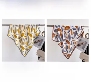 Detail of silk-feel square scarves featuring elegant leaf vein patterns in two colors