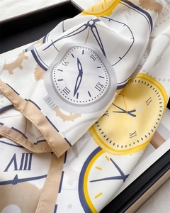 Close-up of silk-feel scarf with vintage clock print and golden yellow accents