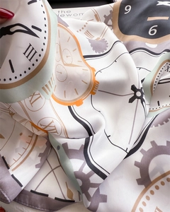 Detailed close-up of silk scarf showing melting clock patterns and fine fabric texture