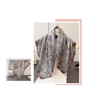 Close-up of elegant paisley print and translucent silk texture on a large square scarf