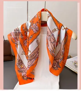 Detailed view of chain and buckle print on premium orange and white silk square scarf