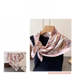 Detail of silk-feel scarf featuring horse bridle and chain print in pink and ivory