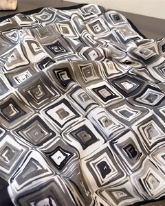Detail of herringbone linen-feel scarf with geometric patterns and twill weave texture